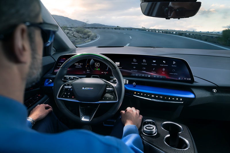 Front View of the 2026 OPTIQ-V Driving Through the Dusk Utilizing its Headlights | Grand Island Cadillac in GRAND ISLAND NE